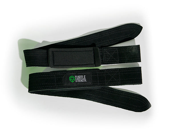 Leather lifting straps lying on a rubber barbell plates