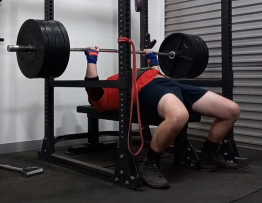 Person performing a bench press in gym