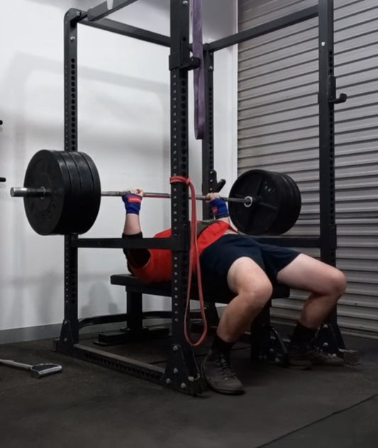 Person performing a bench press in a gym